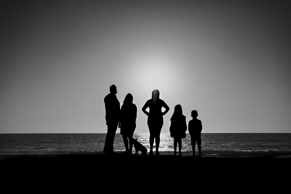 Silhouettes in the sunset, with their pet, the family, and the Mazatlán sea in the background