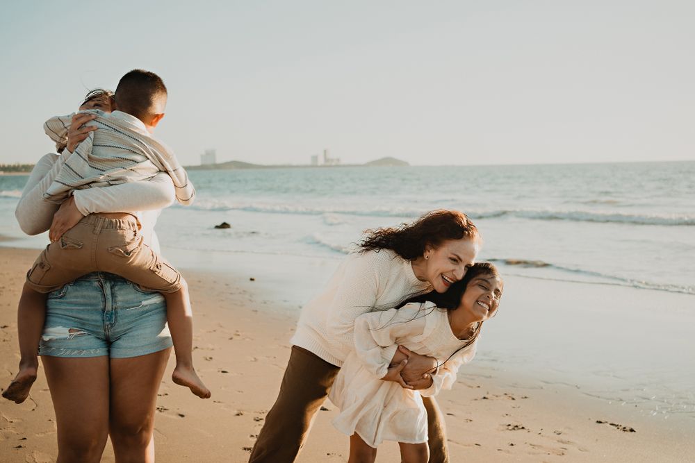 Grandma playing with her grandchildren in a joyful moment by the beach