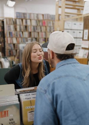 A series of five photos showing people reading and browsing in a library with bookshelves in the background.