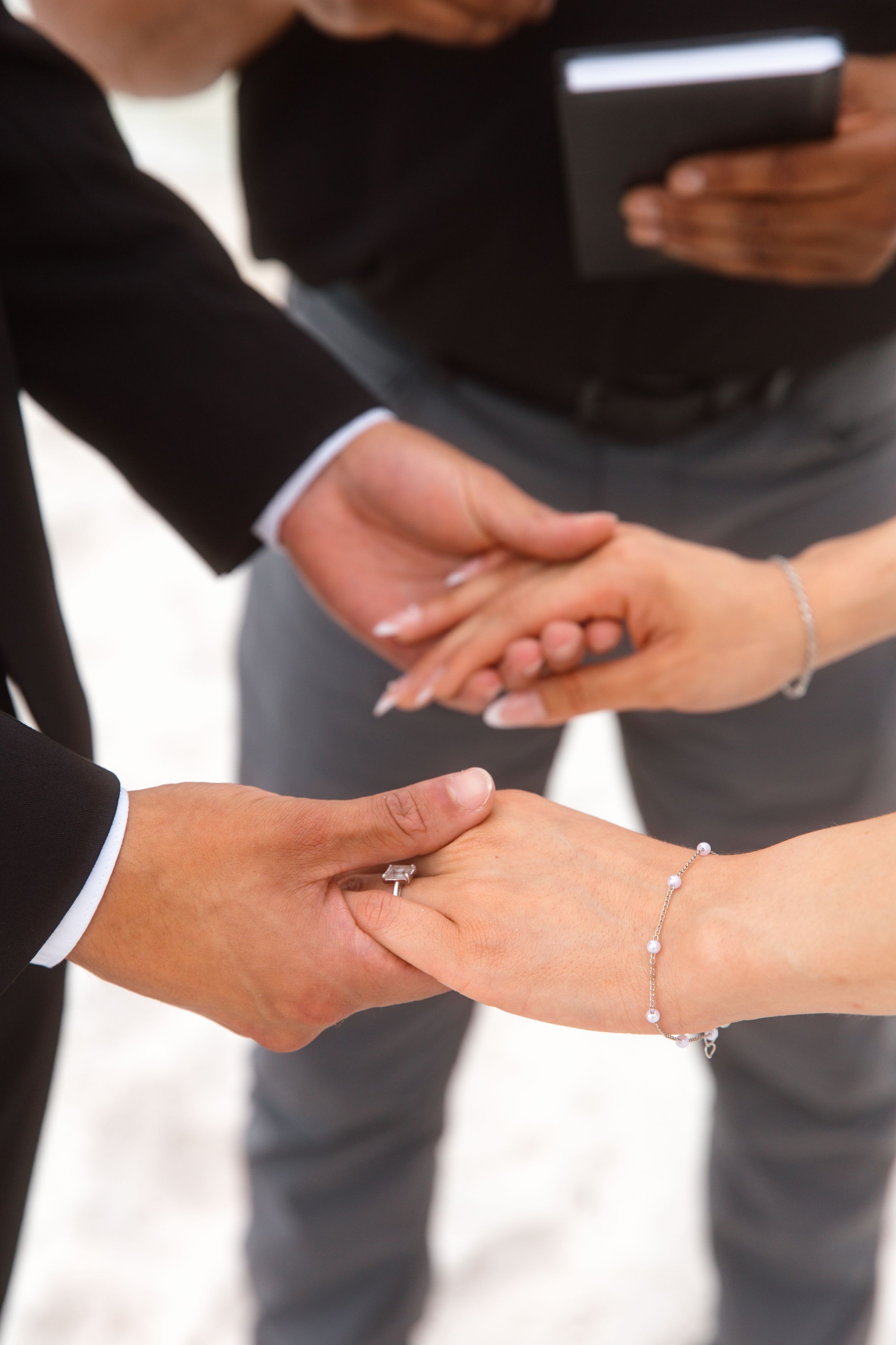 Close up of hands exchanging rings during wedding ceremony.