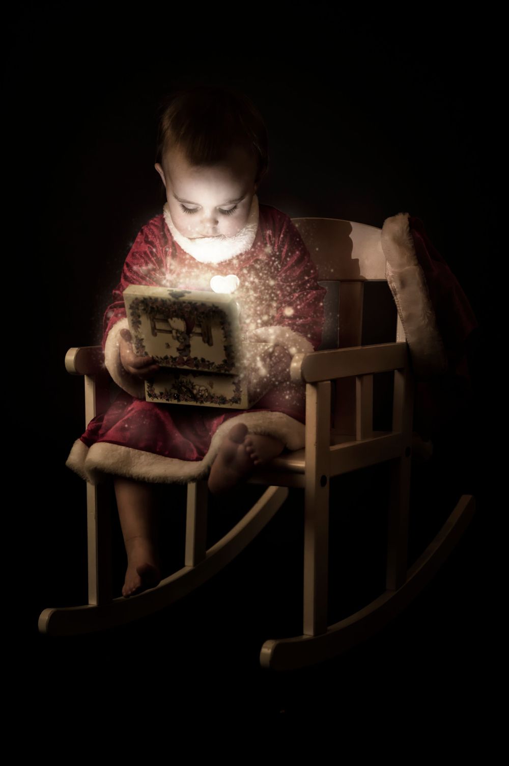 A magical nighttime scene of reading on a wooden rocking chair with glowing light.
