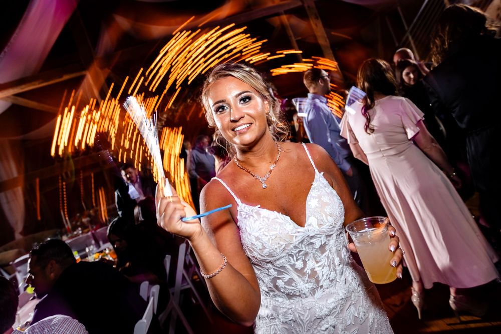 Wedding reception dance party with colorful lighting and guests celebrating on the dance floor.