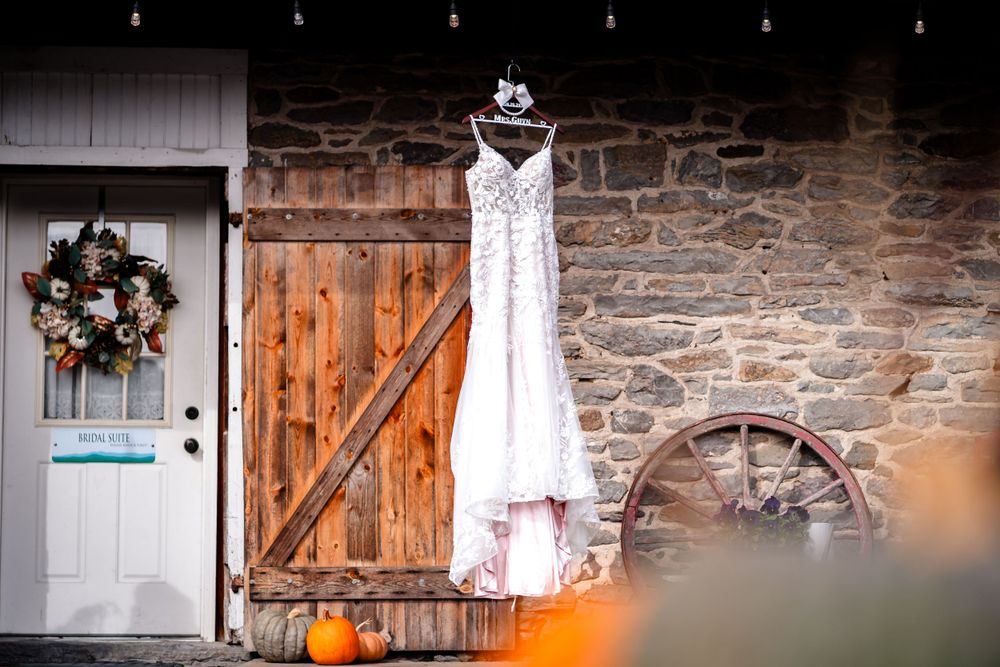 Rustic barn wedding venue exterior with stone walls and wooden doors.
