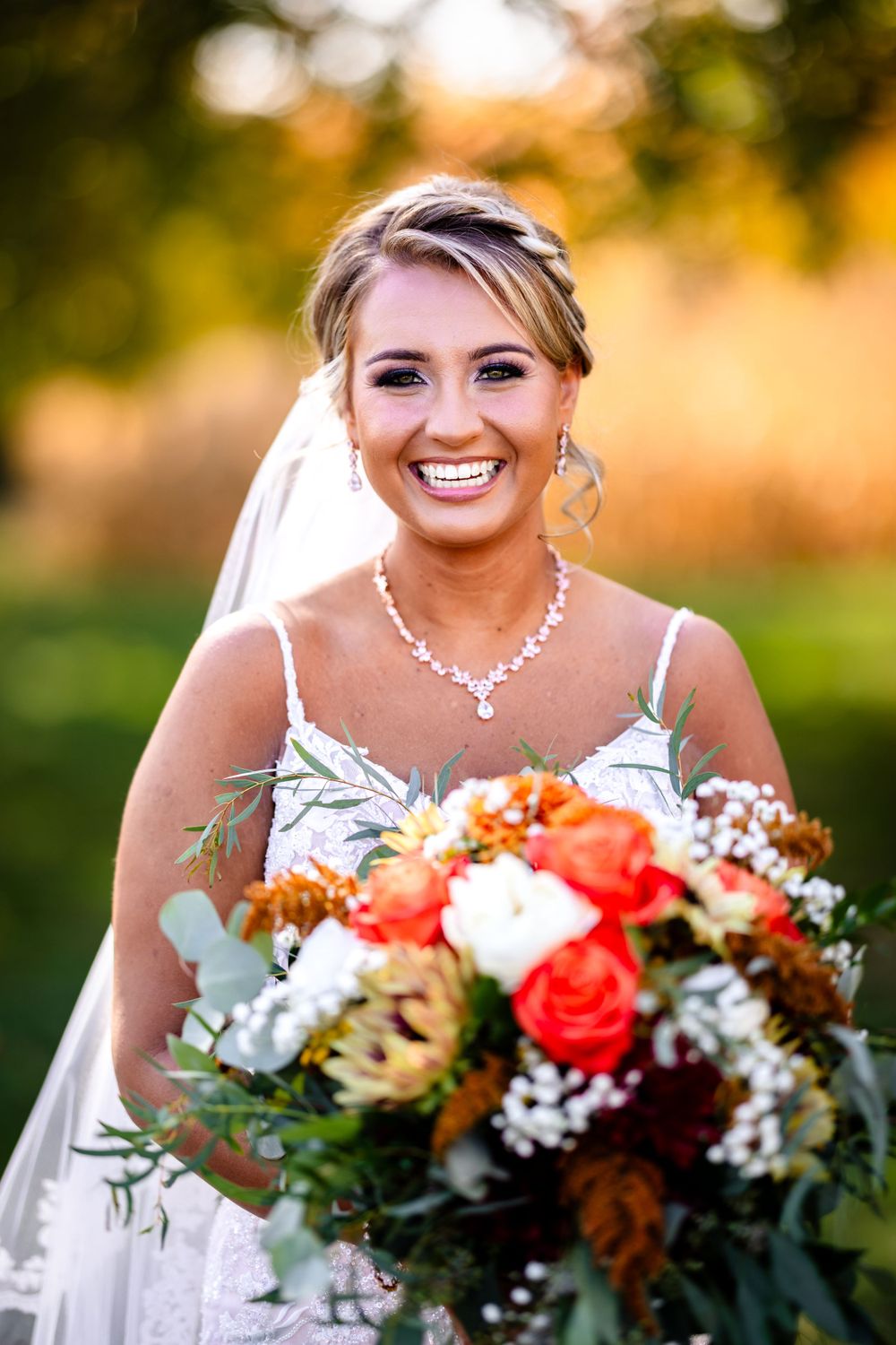 Wedding bouquet featuring coral roses and white flowers with greenery accents.