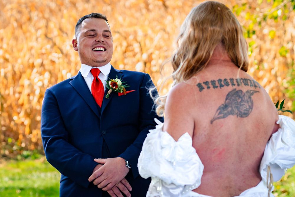 Outdoor autumn wedding scene with golden cornfield backdrop and formal attire.