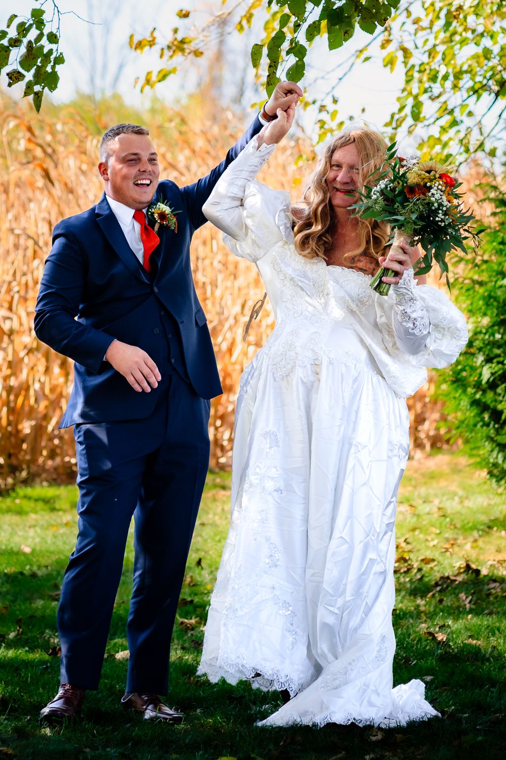 Playful wedding photo session in garden setting with fall foliage.
