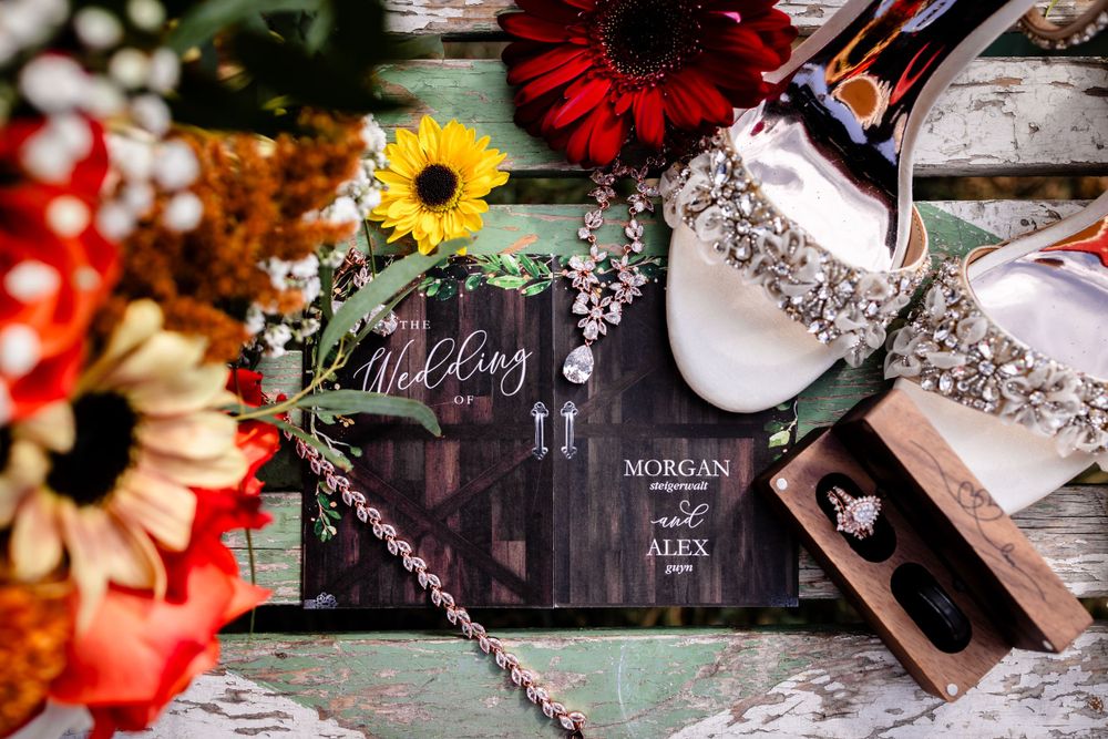 Wedding details featuring red and yellow flowers with decorative signage and accessories.