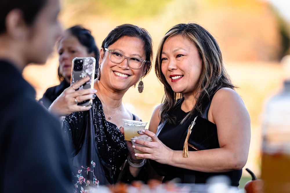 Wedding guests celebrating and taking photos during an outdoor reception.