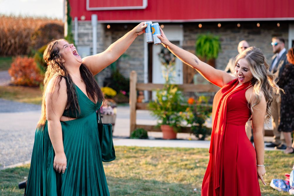 Bridesmaids in alternating red and green dresses at an outdoor wedding.