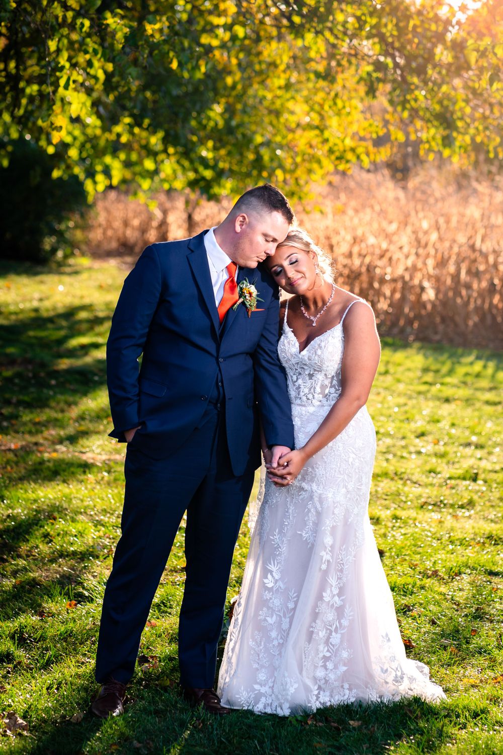 A sunset wedding portrait session in a field with warm golden lighting.