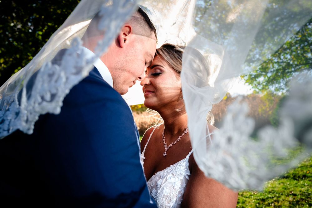 Romantic outdoor wedding photo shoot with a delicate lace veil against a natural backdrop.