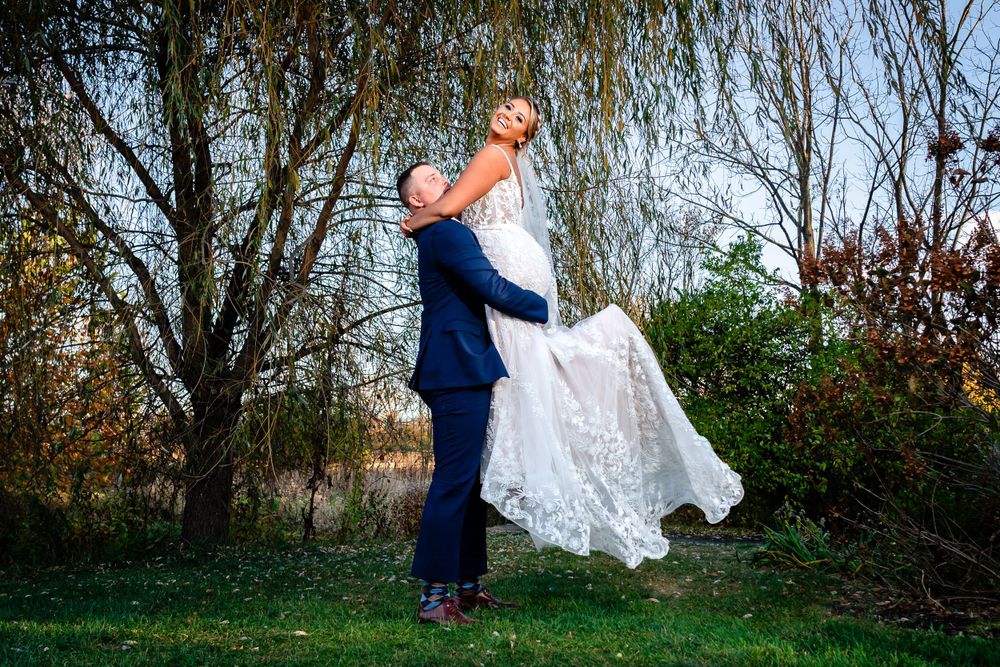 Wedding portraits captured under weeping willow trees in a garden setting.