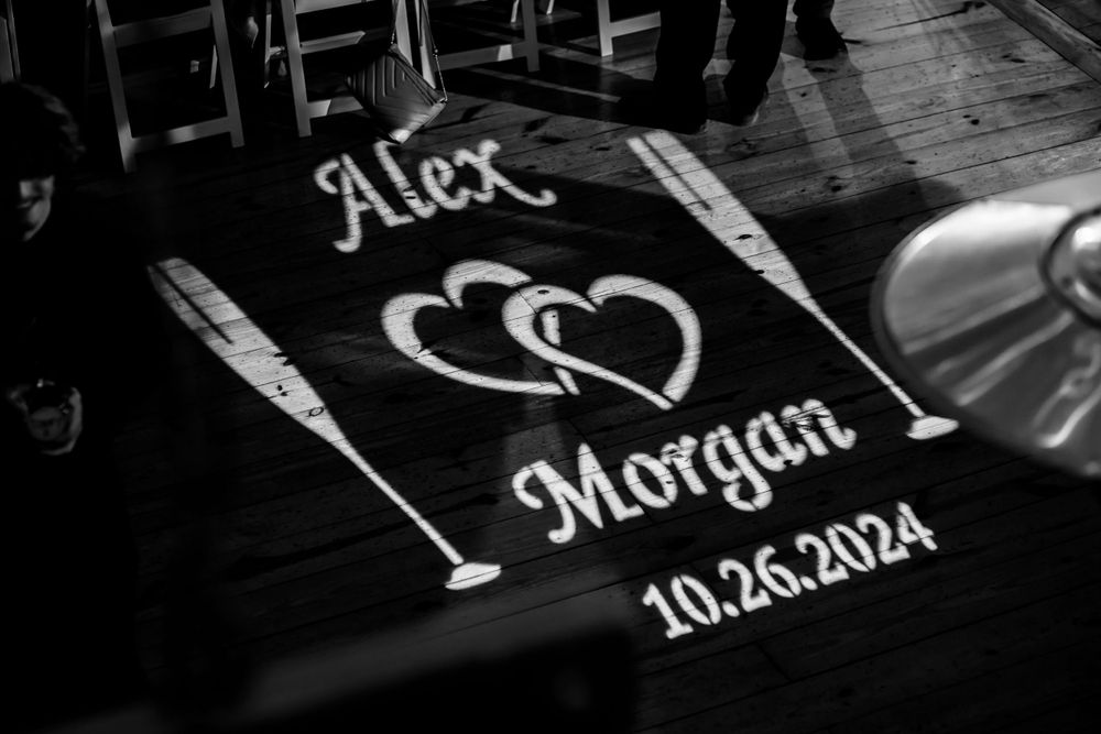 Wedding date and names written in chalk on dark wooden surface.