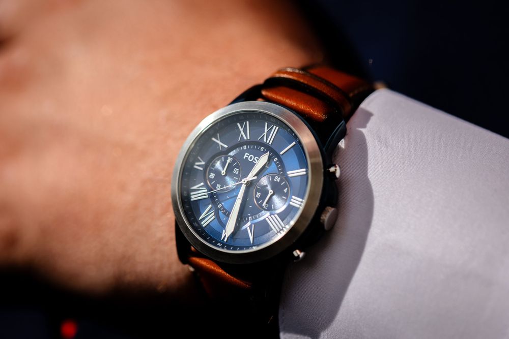 Close-up shots of elegant blue-faced watches with leather straps.