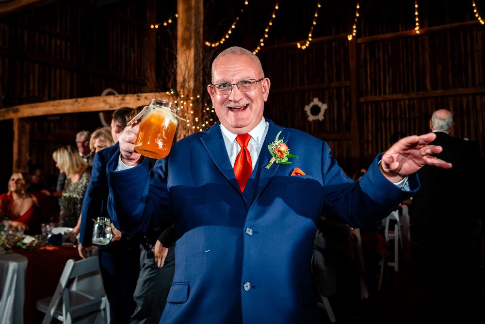 Guests enjoying a lively celebration at an evening wedding reception with string lights in the background.