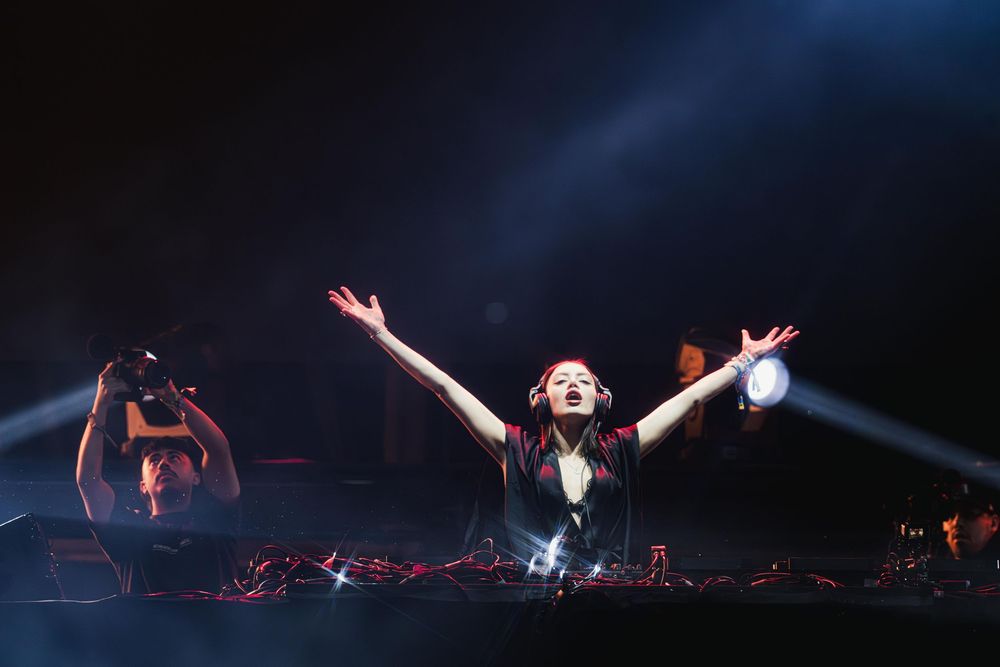 Dramatic silhouettes of performers on a dark stage with theatrical lighting effects create a captivating scene.