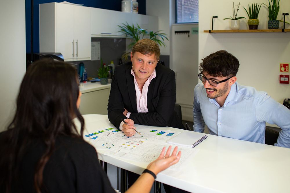Business colleagues collaborating and reviewing documents together at a modern office workspace.