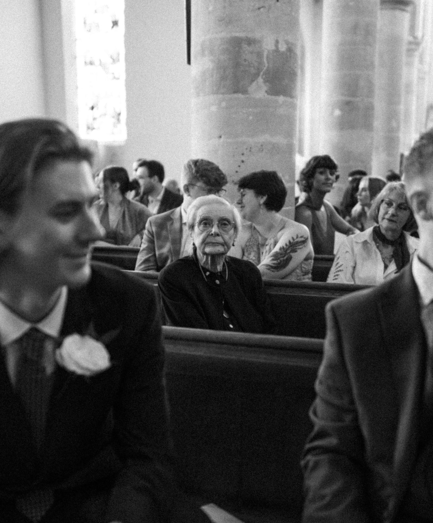Seated elderly woman in a church hall during a wedding ceremony