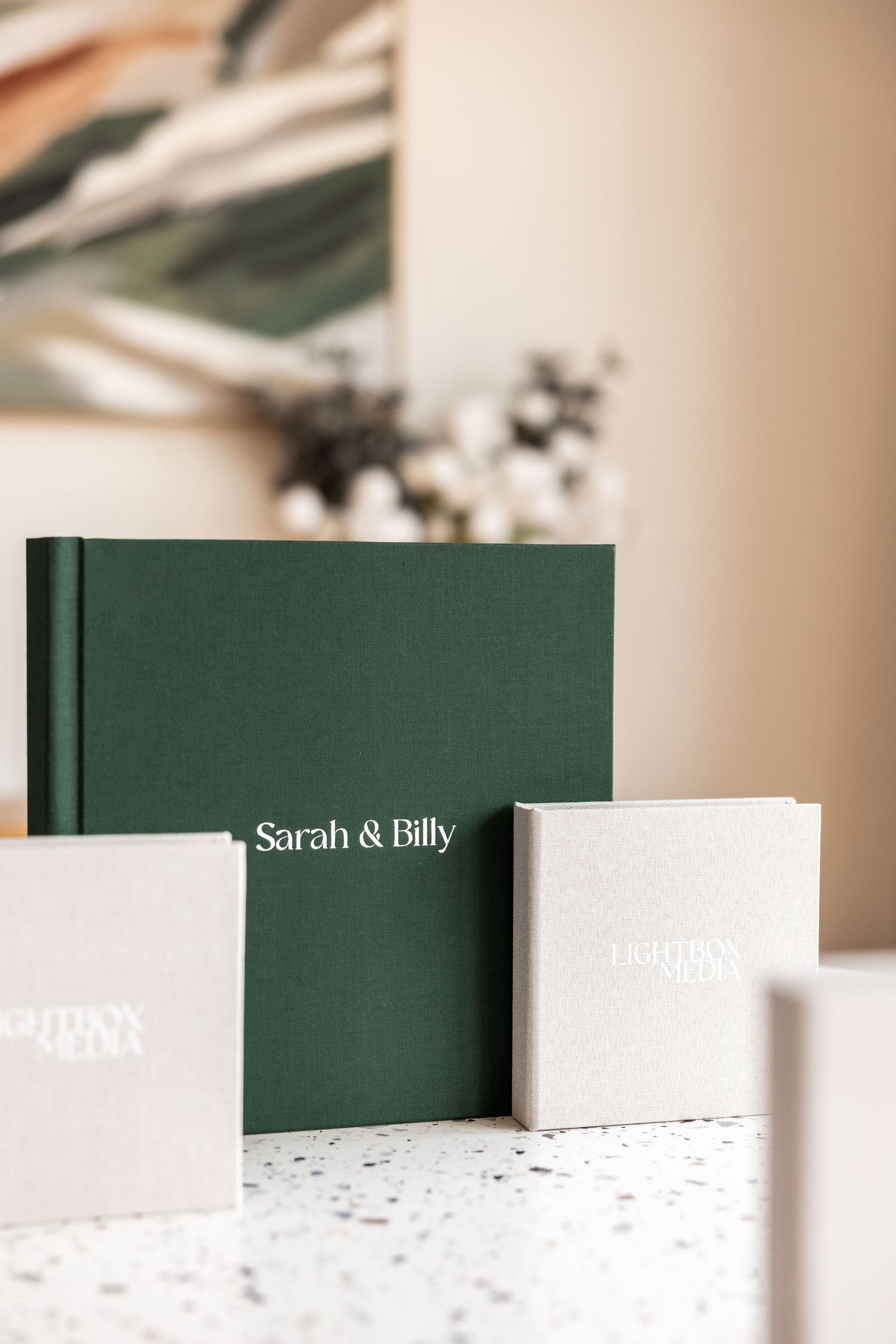 A series of green hardcover books arranged in a minimalist composition against a white background with soft lighting.