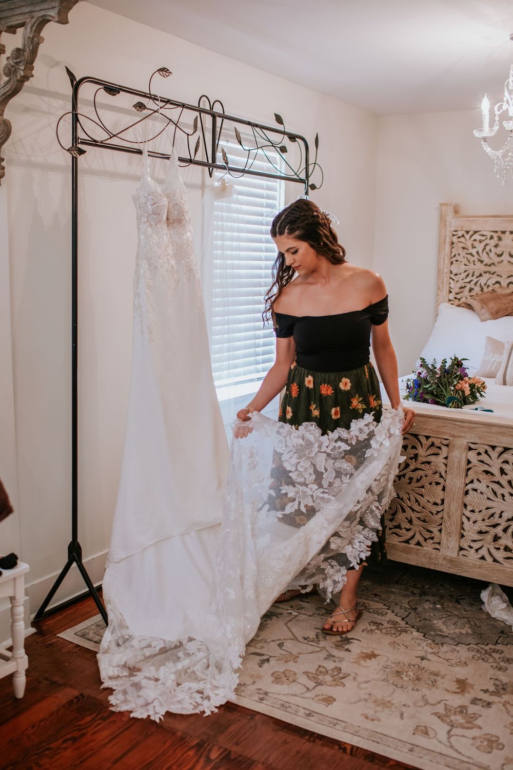 Bride in white lace wedding dress twirling in bright room with decorative mirrors.