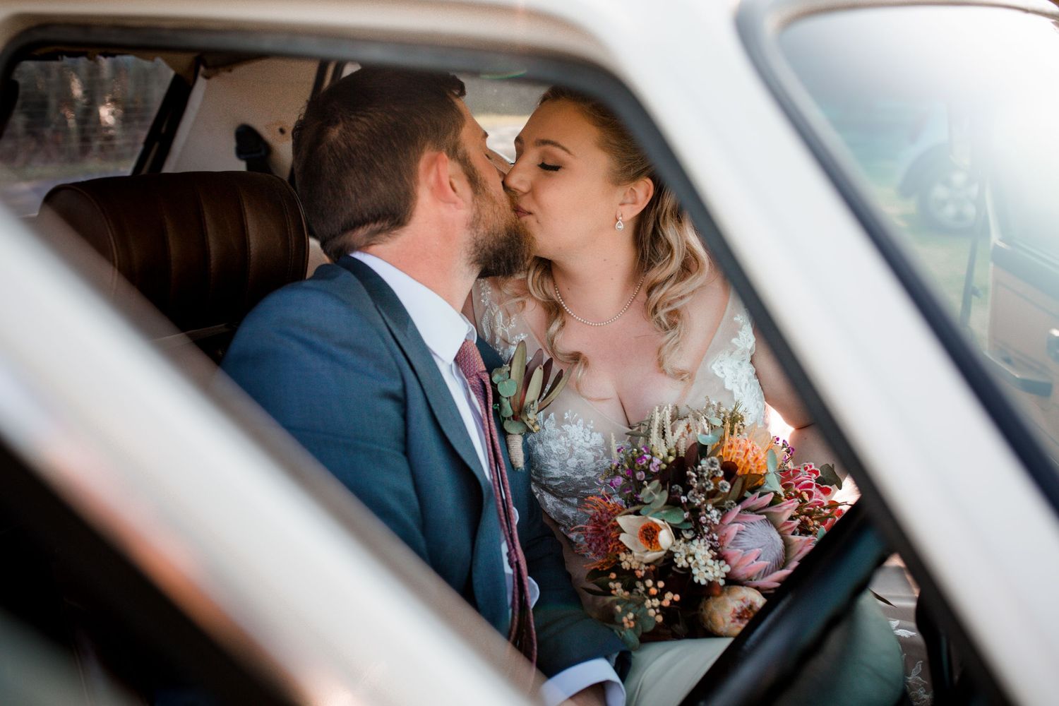 A bride and groom kissing in their vintage VW car in Gerringong, NSW Wedding