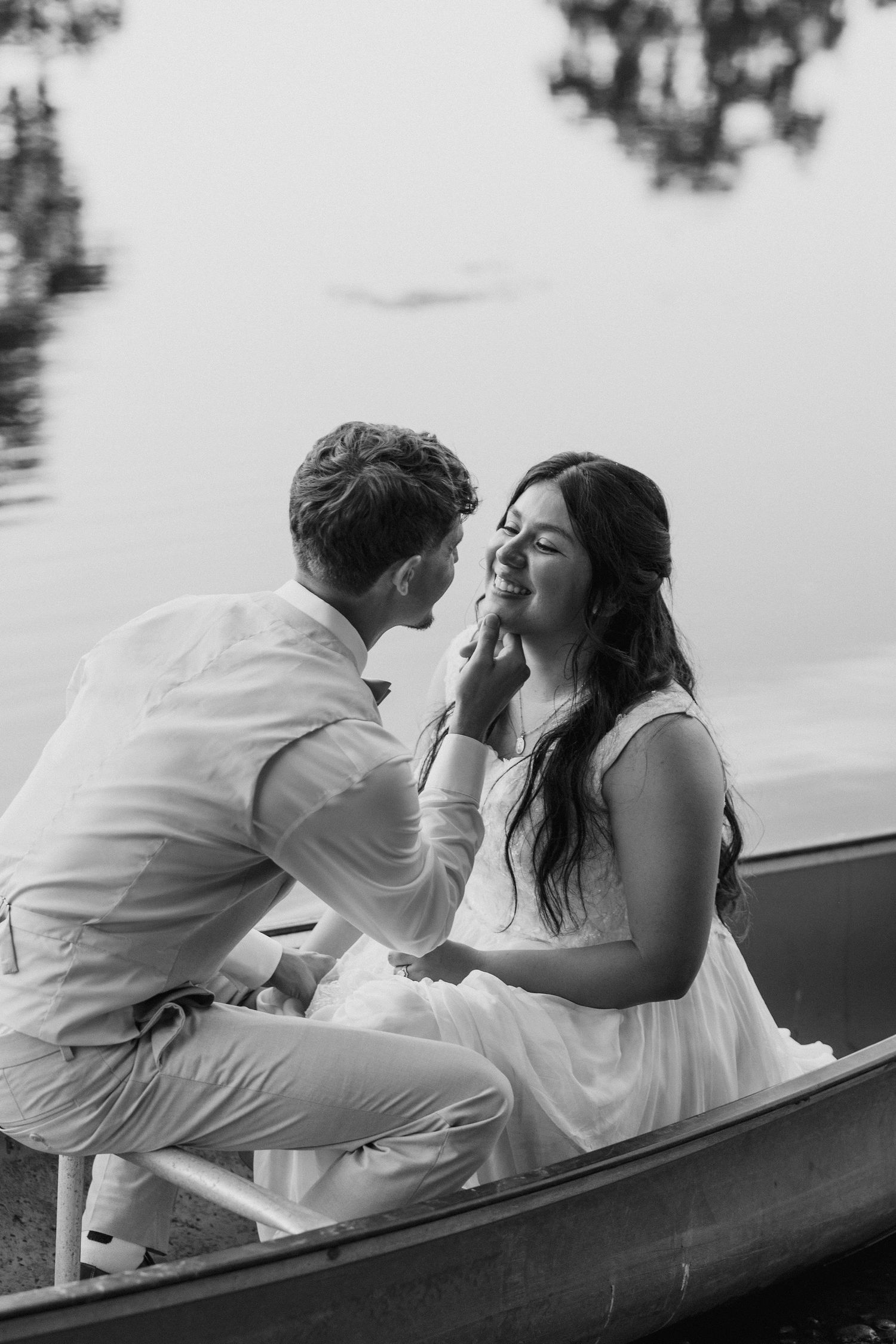Sunset bride and groom portraits in a canoe on a pond