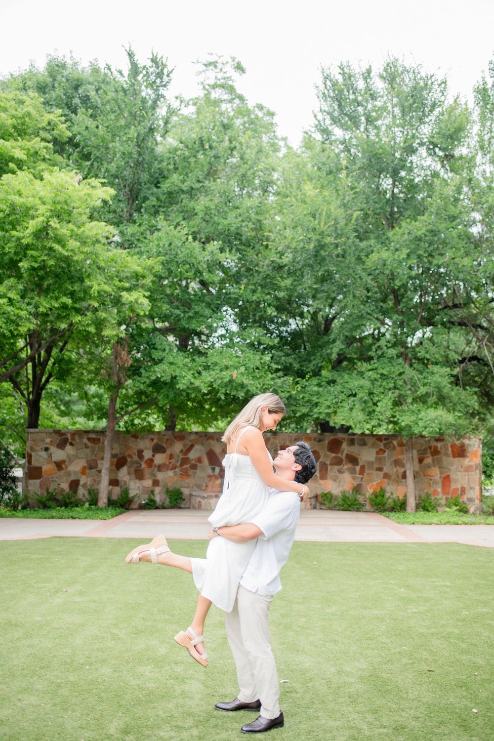 A series of dance poses captured in a grassy outdoor setting with brick walls and trees in the background.