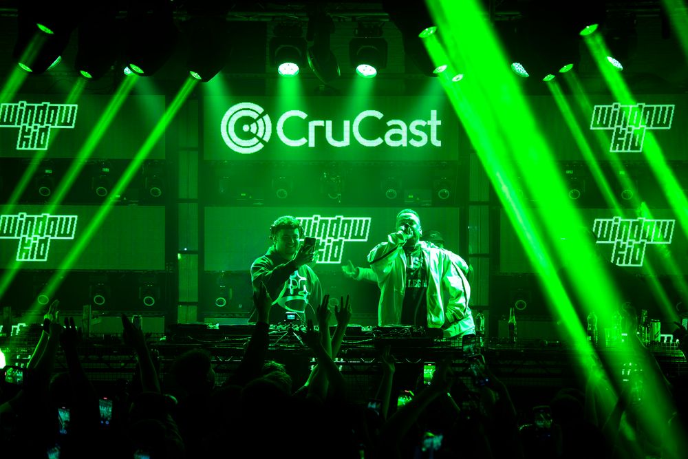 Concert stage illuminated with bright green laser lights and fog effects creating an atmospheric performance environment.