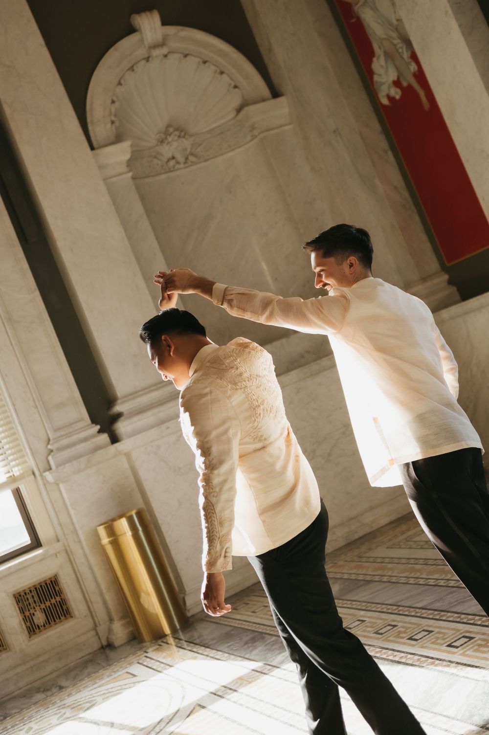 A sequence of artistic dance movements captured in a marble hallway with dramatic lighting.