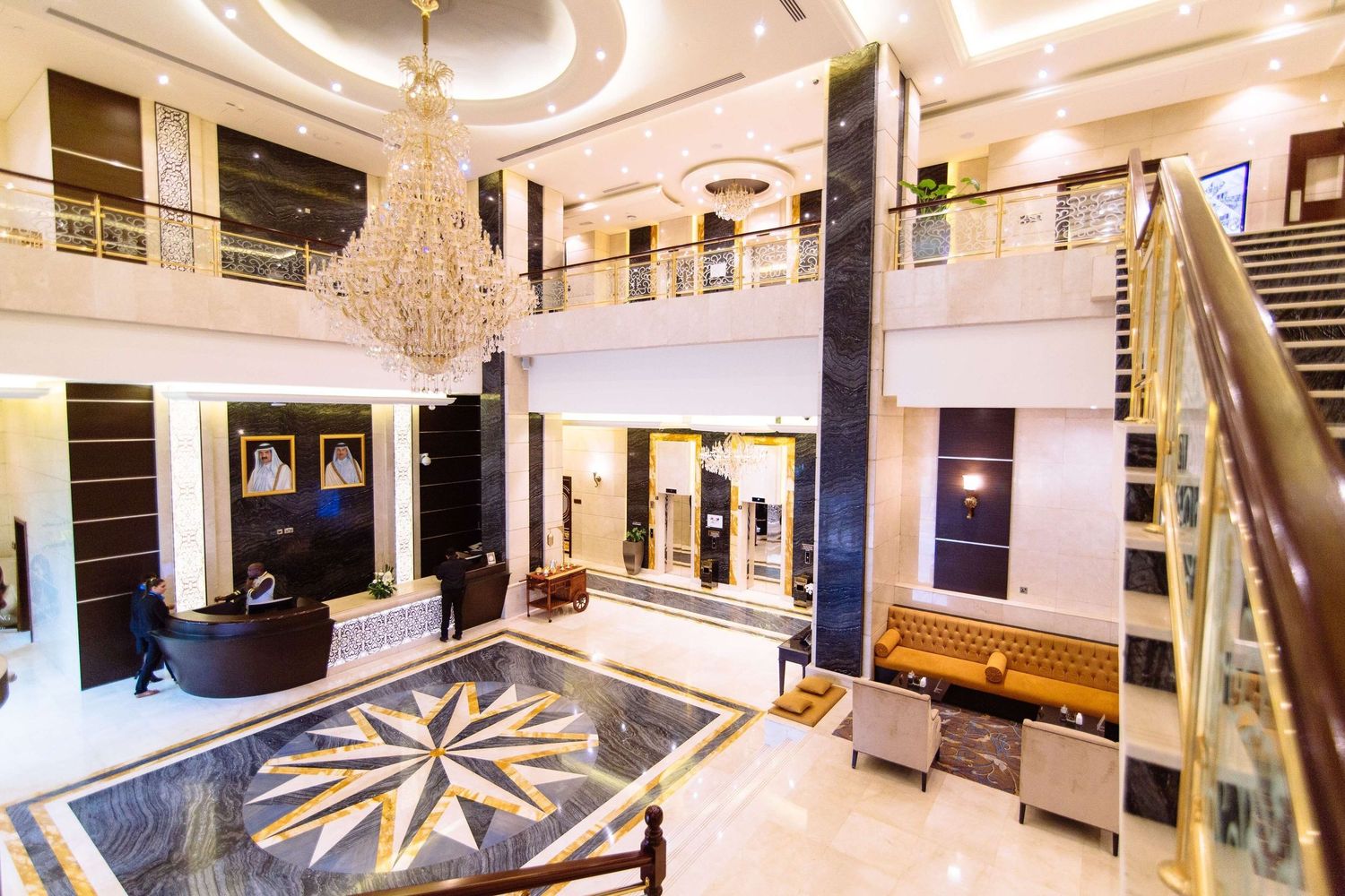 Luxurious hotel lobby interior with ornate crystal chandeliers, marble floors and elegant modern furnishings.