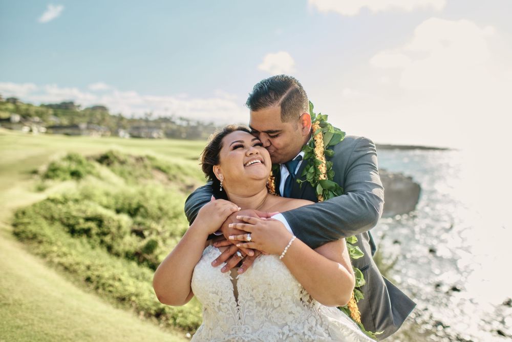 Newlyweds share tender moments during their coastal wedding photoshoot.