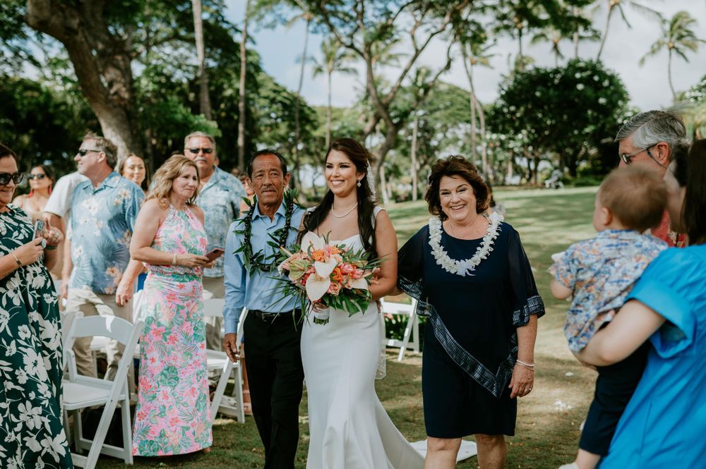 Wedding guests gather on lawn during outdoor celebration.