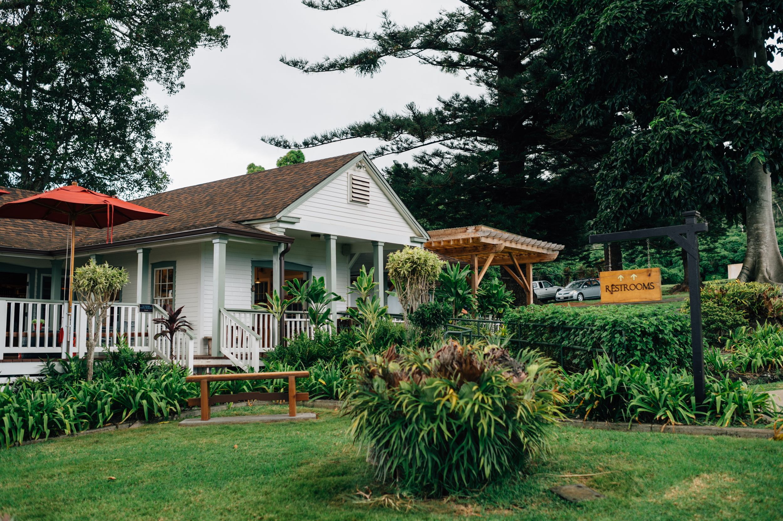 Panoramic view of ranch buildings with tropical landscaping and covered porches.