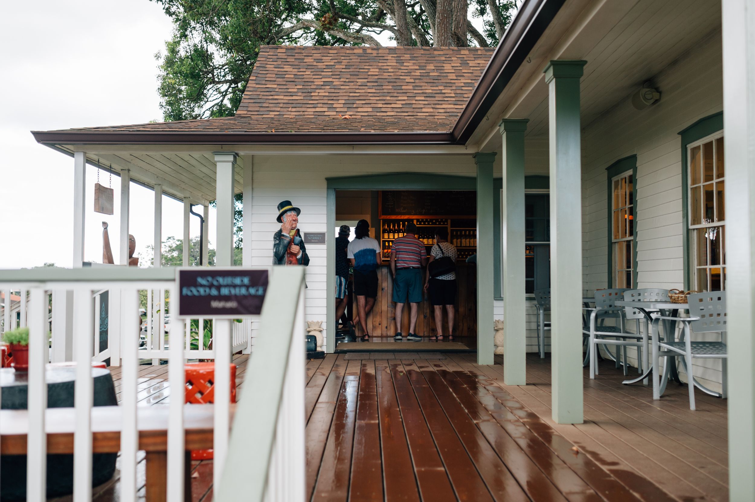Covered walkway with wooden columns and traditional Hawaiian architectural details.