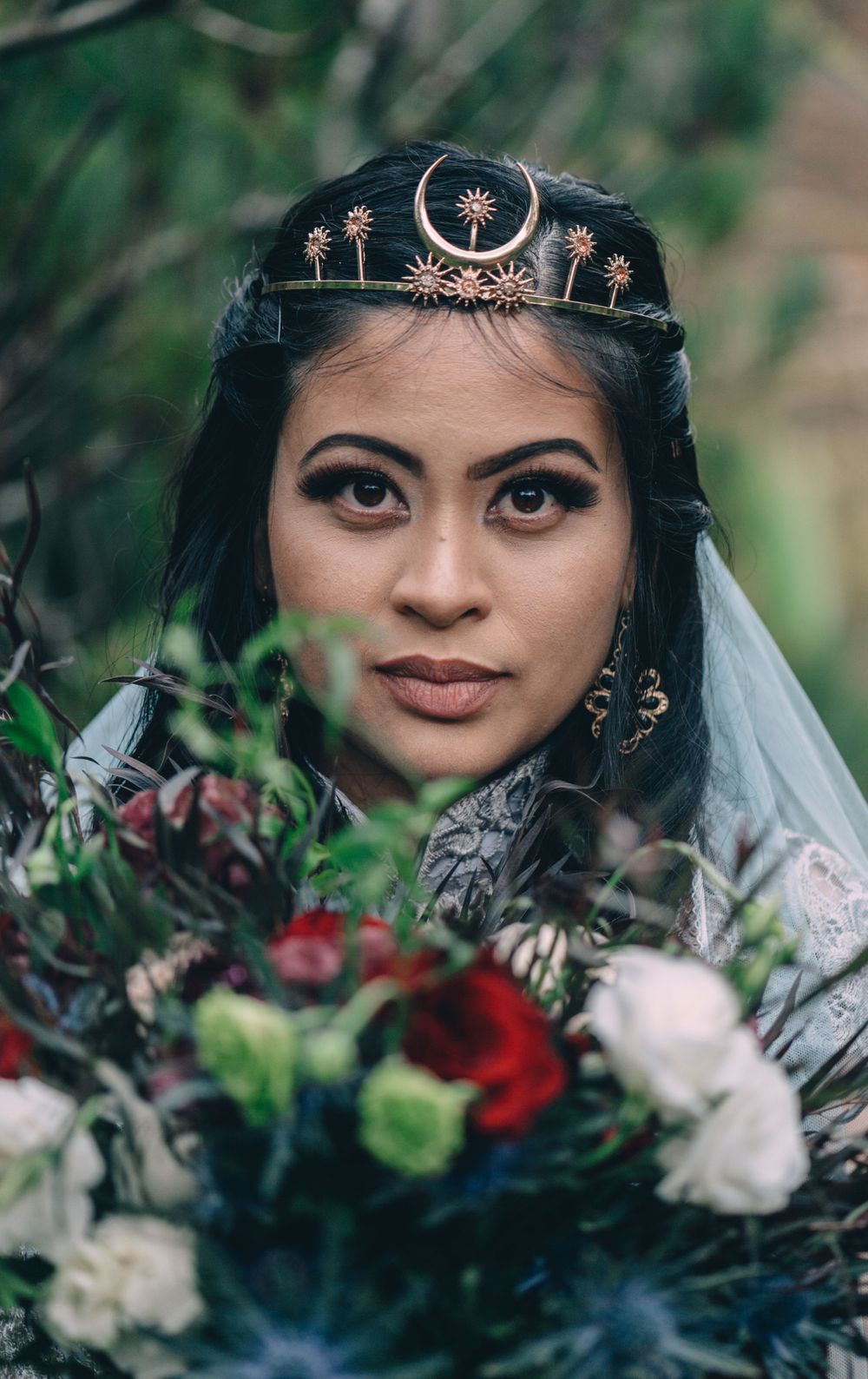Close-up wedding portraits with celestial headpiece and dramatic burgundy bouquet details.