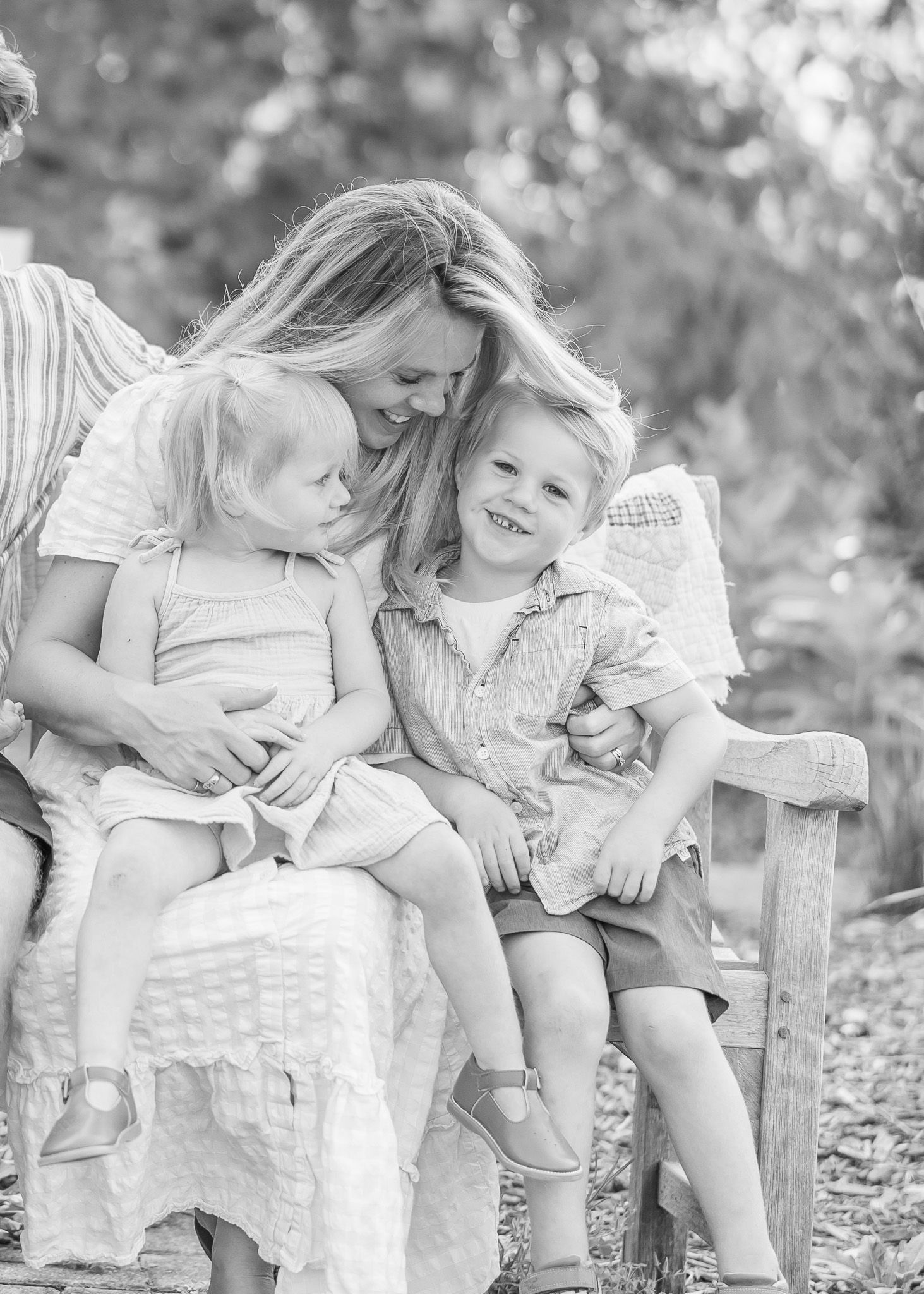 A series of black and white photographs showing tender moments between a parent and child on a rustic wooden bench.