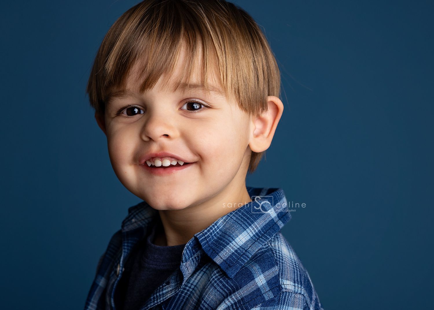 A series of headshots against a dark blue background showing a young child in a blue plaid shirt with different expressions.