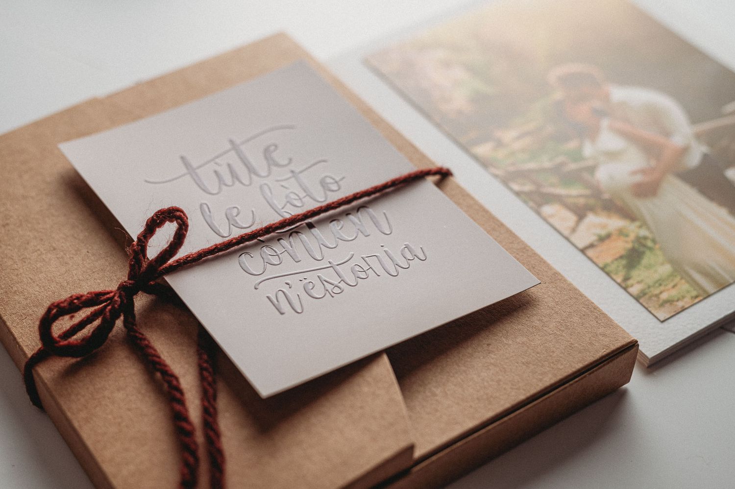 A brown paper wrapped album with handwritten text tied with twine string.