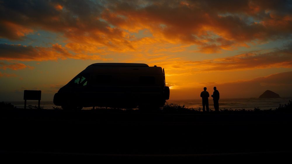 Dramatic orange and red sunset sky with silhouetted mountains creating a stunning panoramic vista.