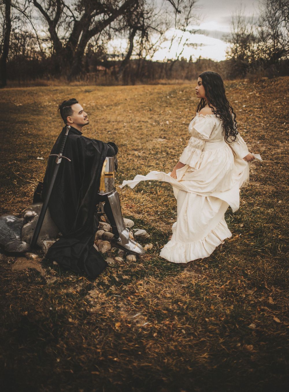 Moody cinematic couple session in a field with warm autumn tones, capturing connection and natural emotion