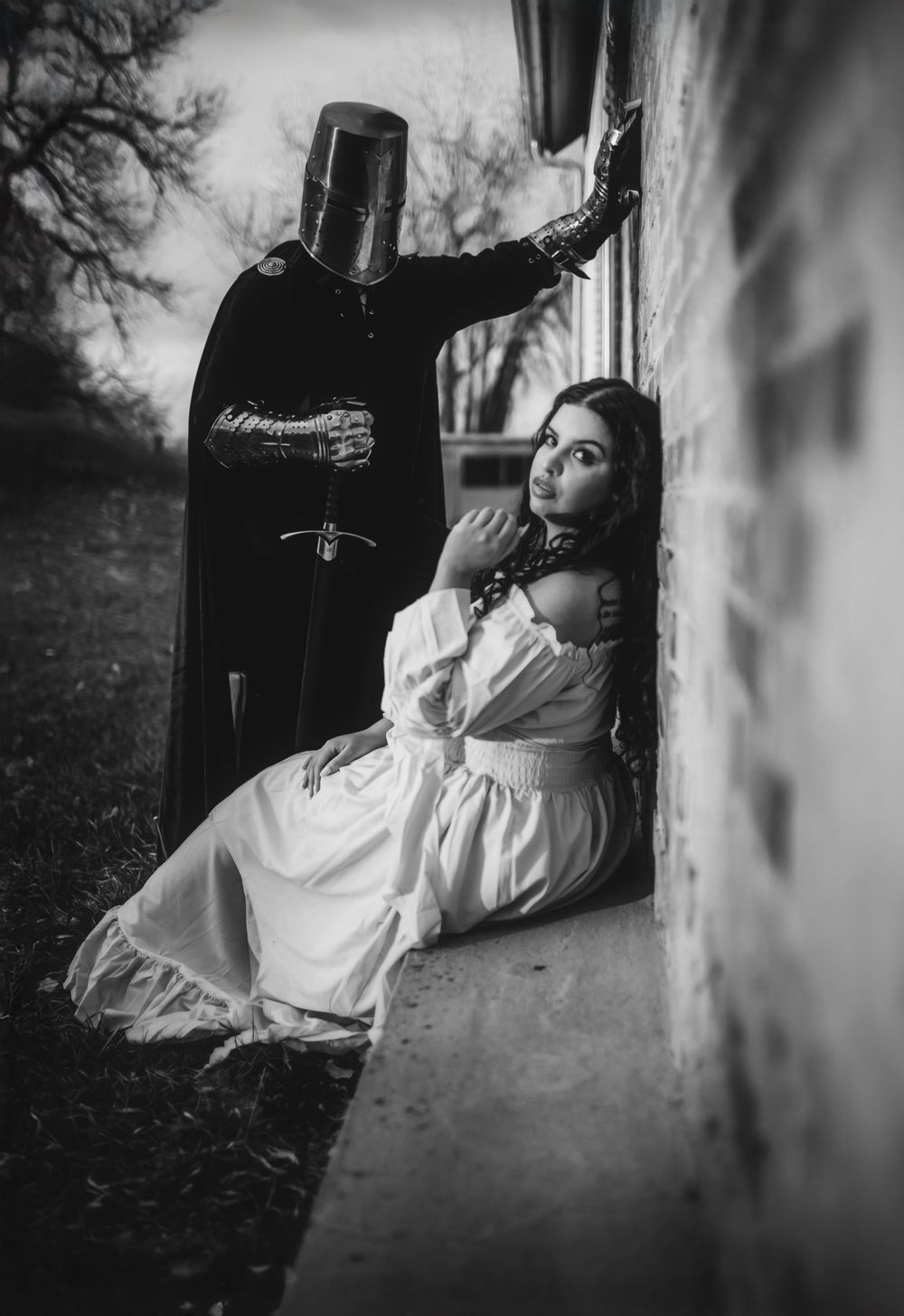 Black and white cinematic portrait of couple in dramatic lighting against wall in Northern Colorado