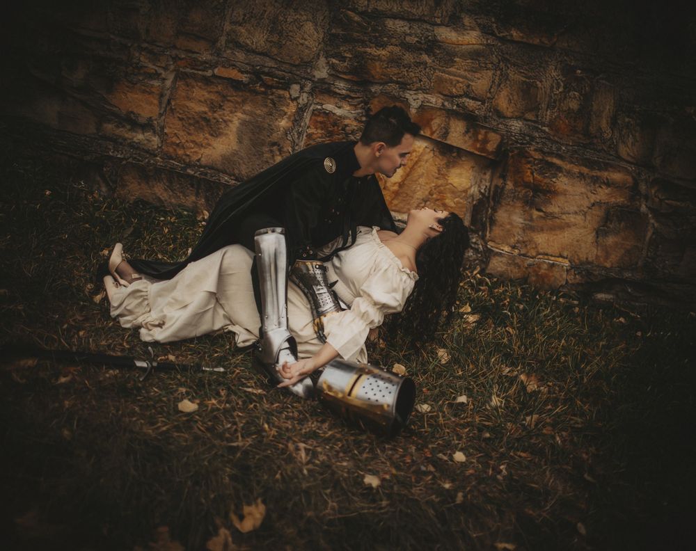 Romantic couple lying together during cinematic portrait session in Northern Colorado, captured in a moody storytelling style