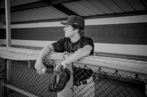 Black and white photo of baseball players in dugout during game.