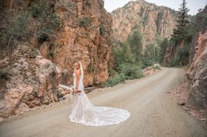 Winding dirt road through red rock canyon with elegant bridal portraits.