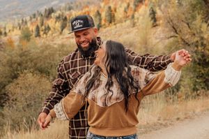 Casual outdoor scene in autumn mountains with plaid shirts and natural scenery.