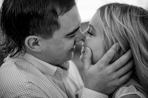 An intimate black and white portrait of a romantic moment between two people.