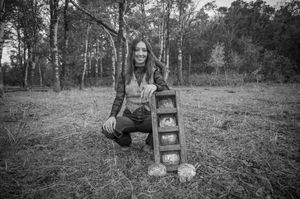 Black and white portrait session in natural wooded setting with vintage props.