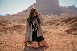 A photographer captures images with a camera against a backdrop of desert mesas.