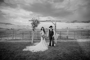 Dramatic black and white landscape of an outdoor wedding ceremony with mountain backdrop.