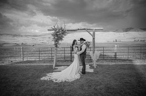 Wide angle black and white shot of a country wedding ceremony with rustic details.
